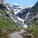 A walking trail through the mountains with the Kjenndalen Glacier in the background